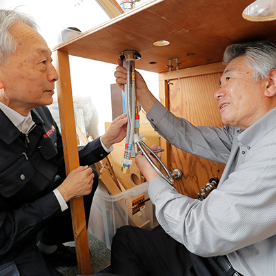 浄水器の取り付け方法の講習を行う講師