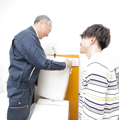 トイレの交換の実技を行う学生と指示をする講師